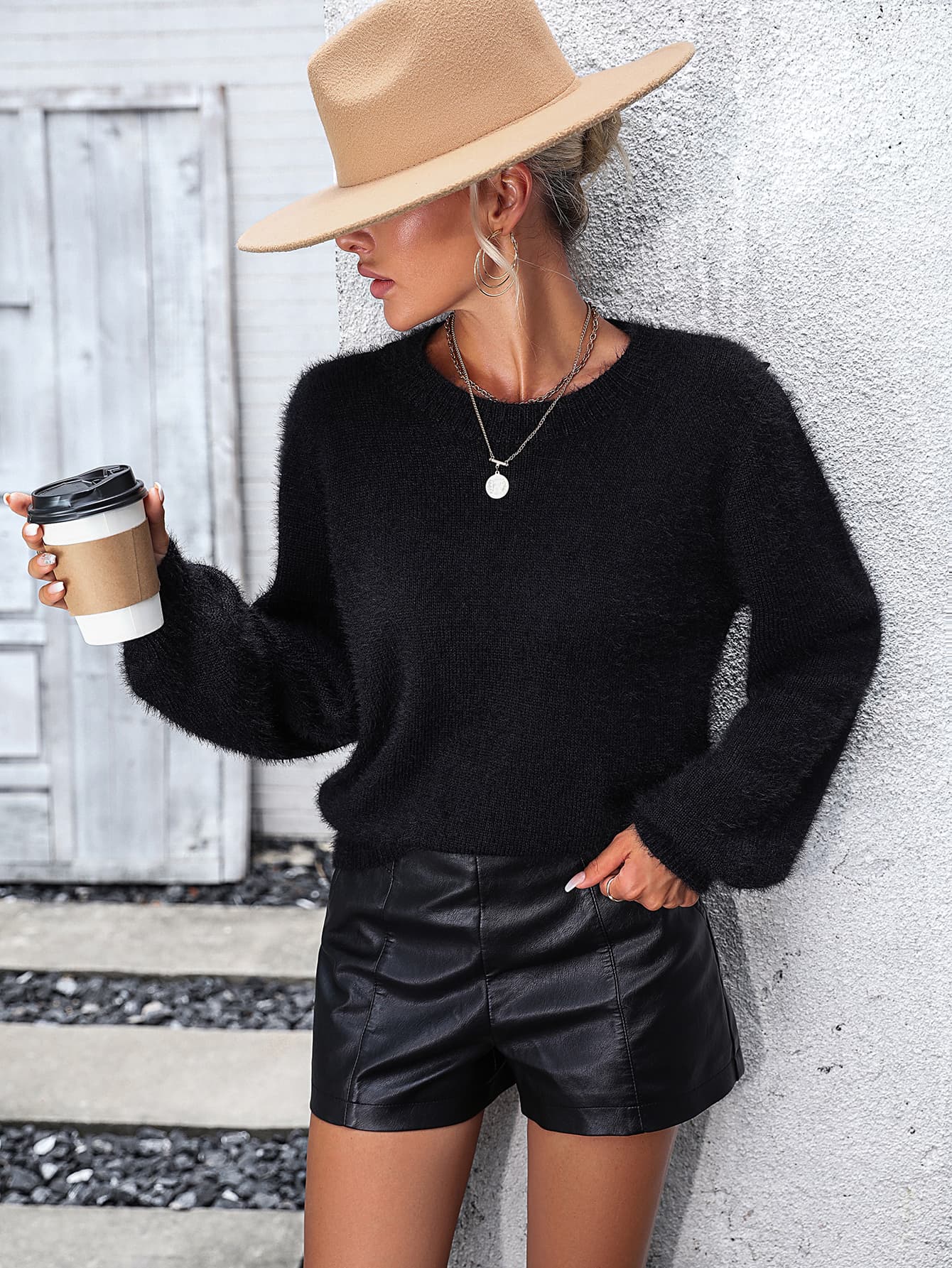 Black fluffy knit sweater with crew neck and balloon sleeves, featuring lace back detail.