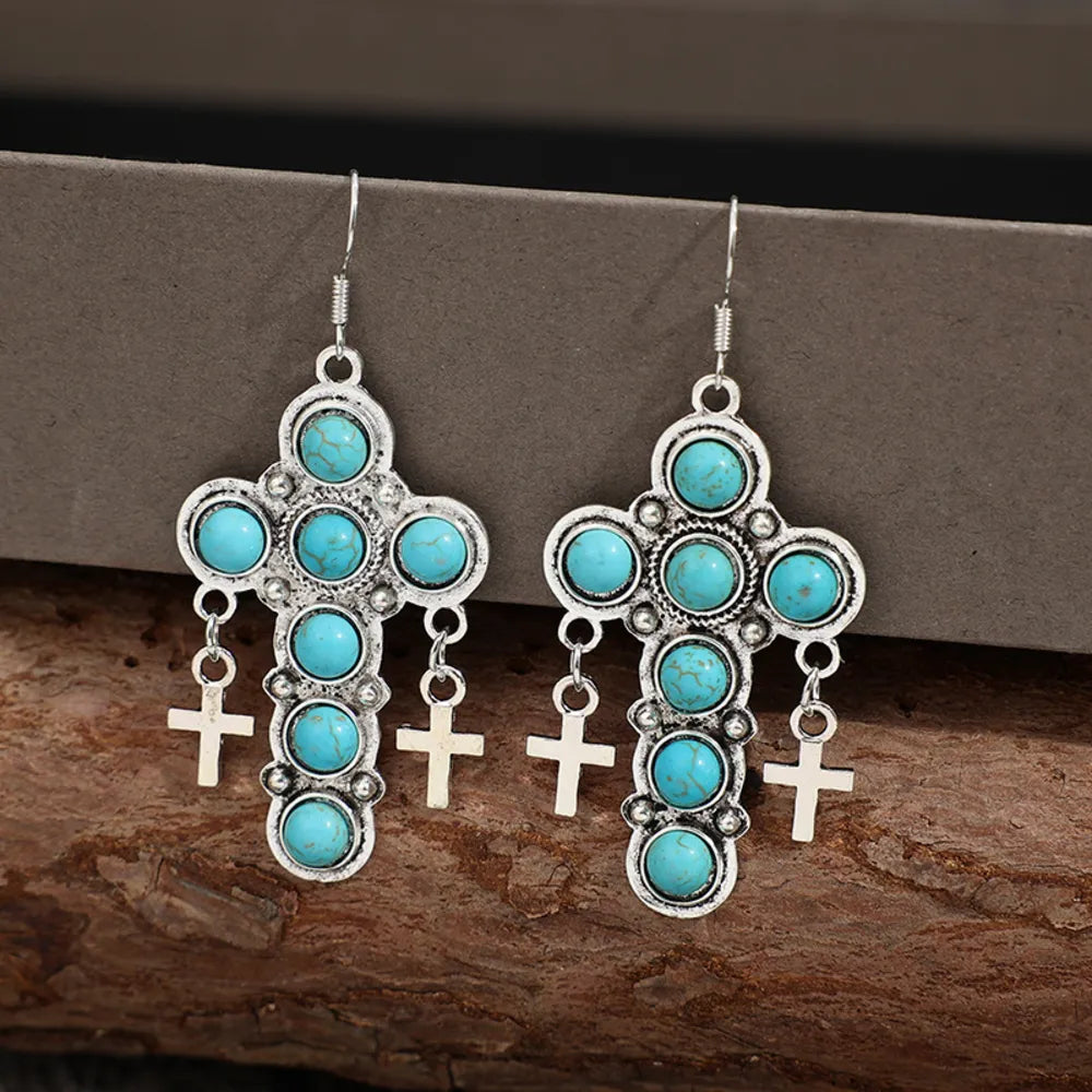 Southwestern turquoise cross dangle earrings with small cross charms.