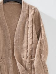 Tan knit cardigan with cable knit details and pockets.