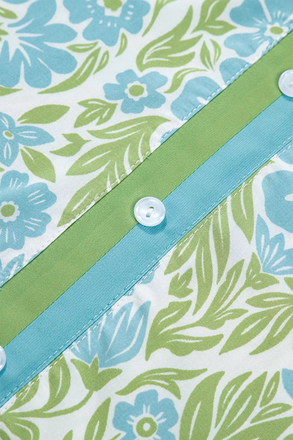 Mini dress with blue floral print, green leaves, contrast trim and buttons.