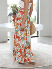 Palazzo trousers with a colorful floral print in orange, turquoise, and sage green.