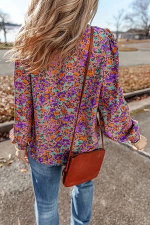 Purple floral print blouse with gathered sleeves and button cuff.