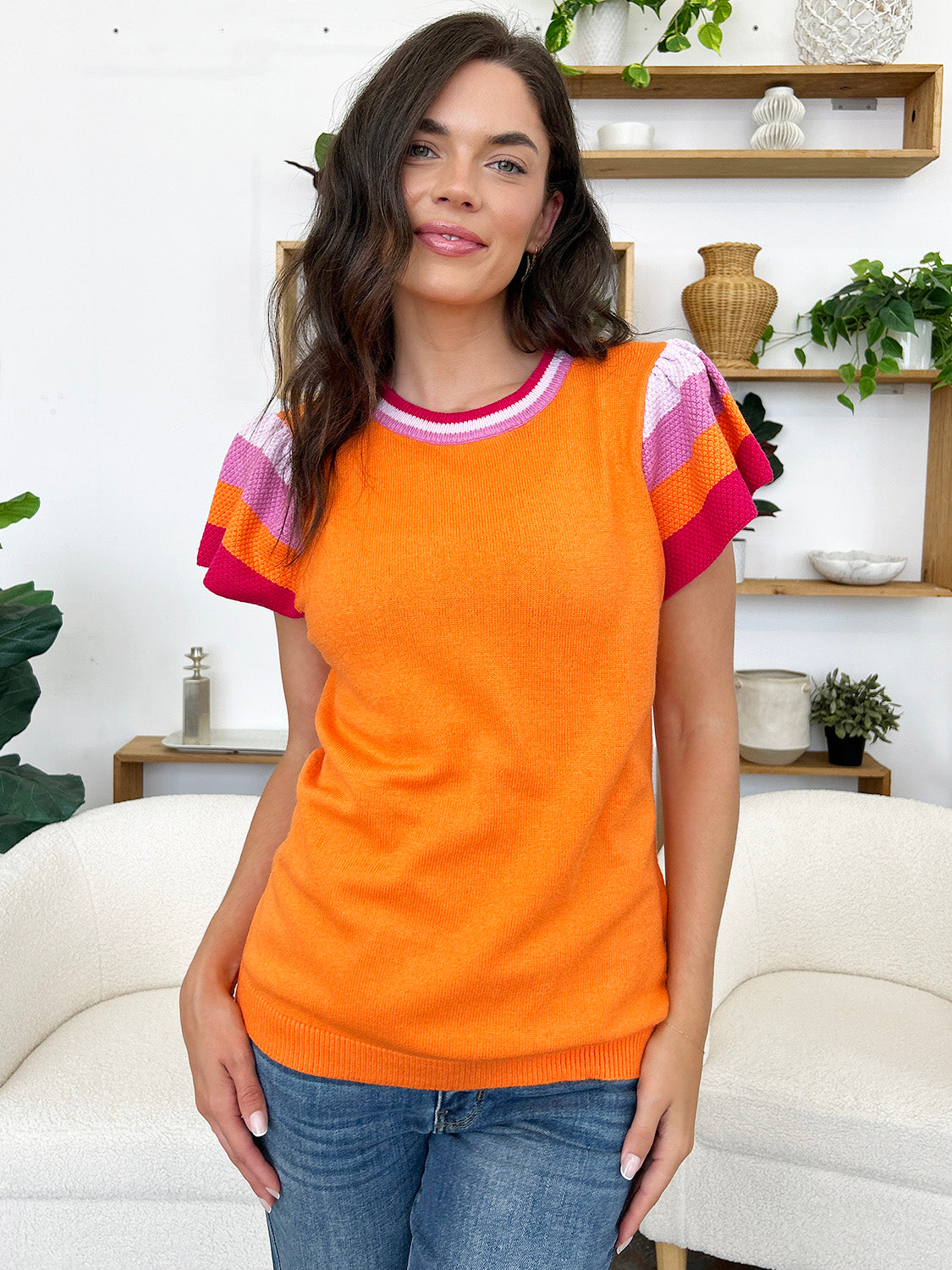 Orange knit blouse with flutter sleeves and colorblock trim