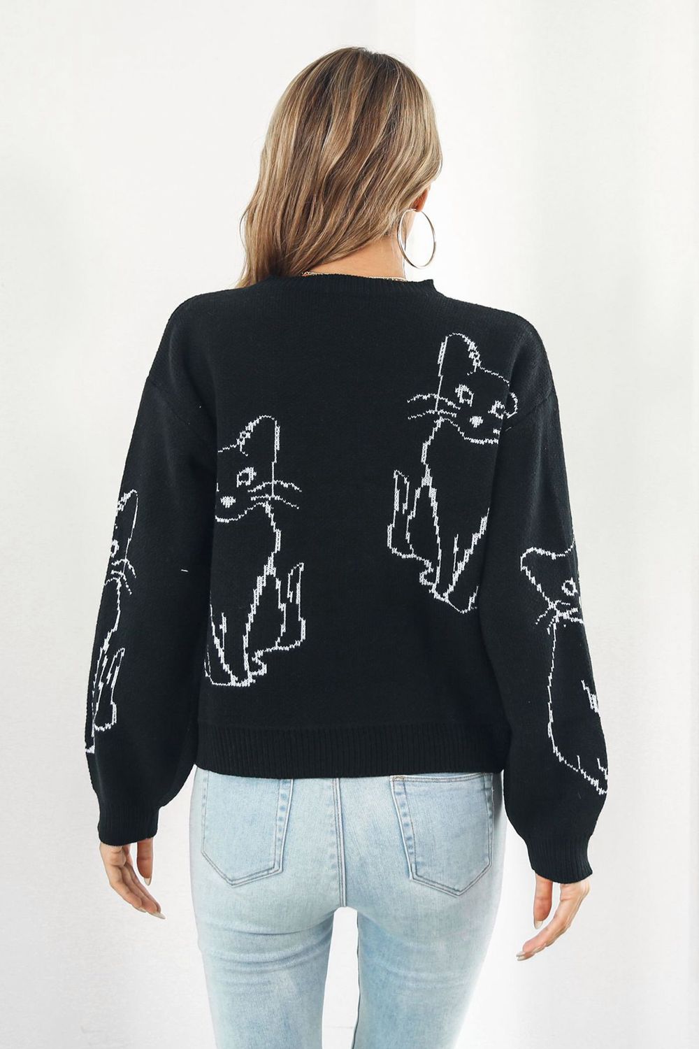 Black acrylic sweater with white cat intarsia knit pattern, crew neck, long sleeves.