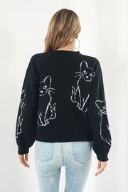 Black acrylic sweater with white cat intarsia knit pattern, crew neck, long sleeves.