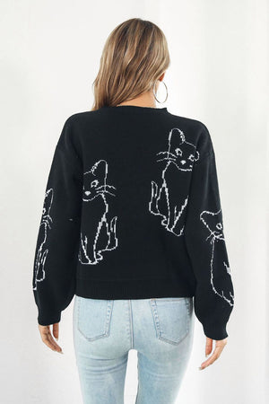 Black acrylic sweater with white cat intarsia knit pattern, crew neck, long sleeves.