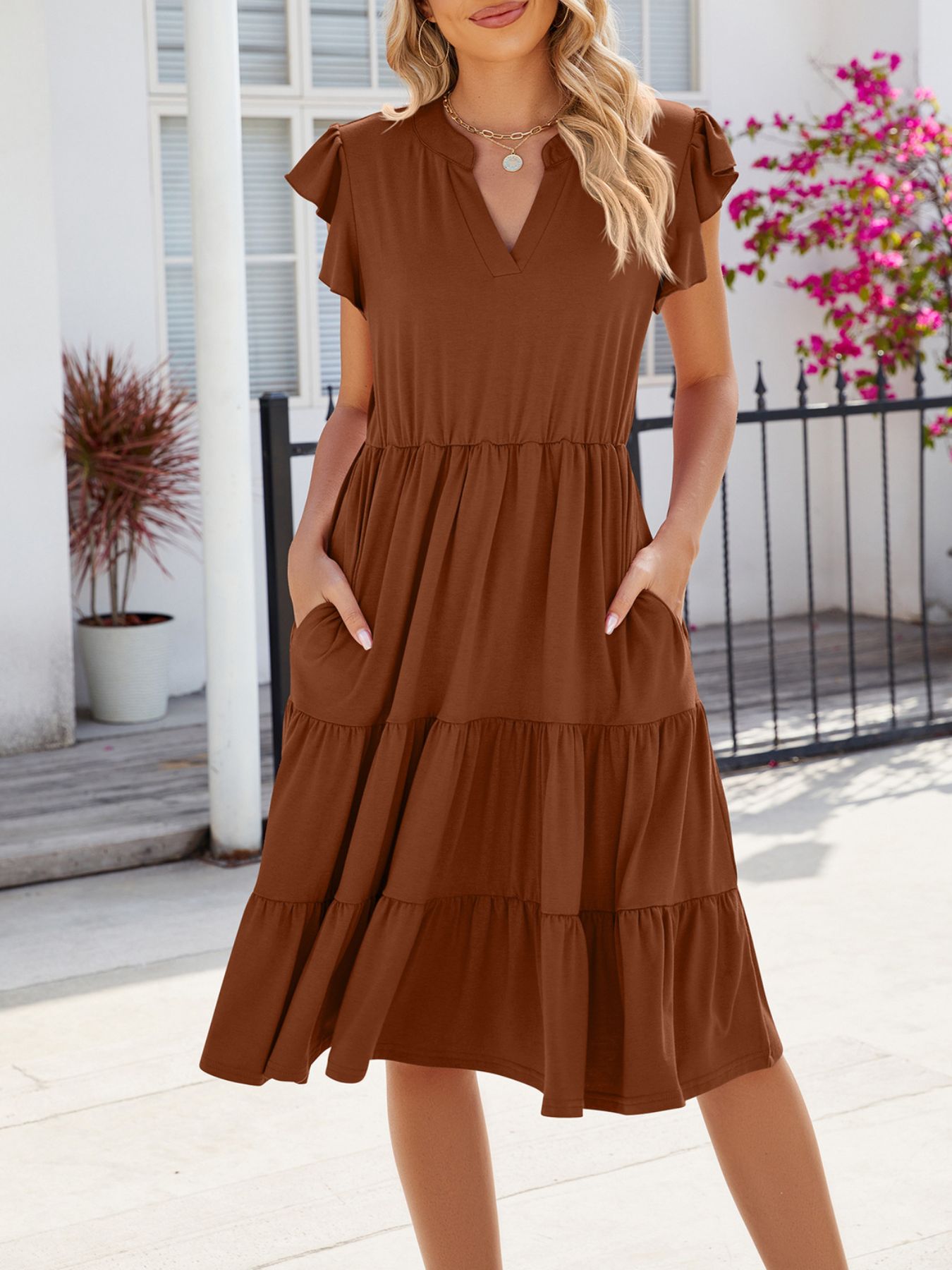 Brown ruffled midi dress with notched V-neck, flutter sleeves, and tiered skirt with pockets.