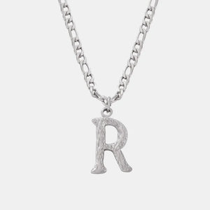 Textured initial pendant necklace with a silver chain and an R charm.