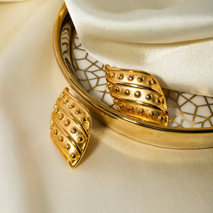 Sculpted gold leaf stud earrings with raised dot details, 18K gold-plated.