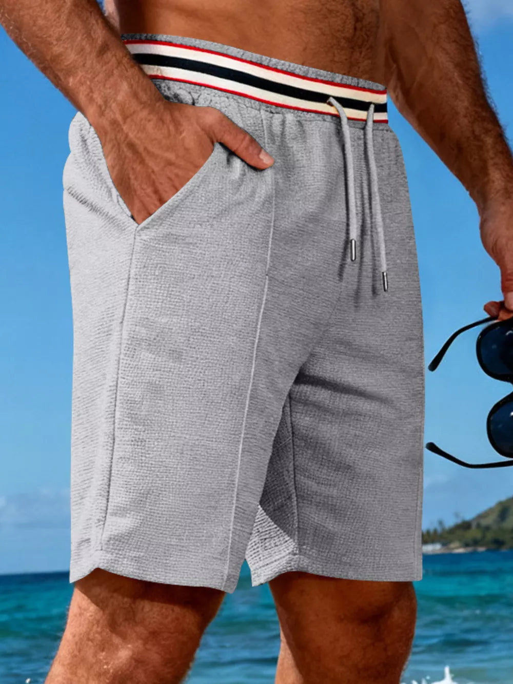 Gray textured drawstring shorts with striped waistband and side pockets.