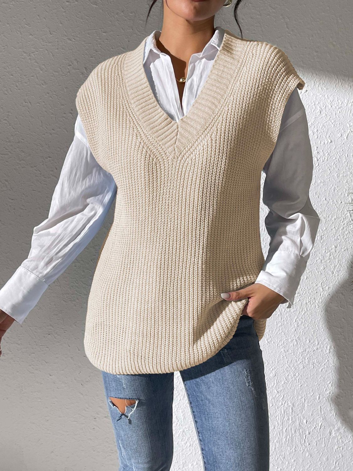 Beige textured knit V-neck sleeveless top over a white button-down shirt.