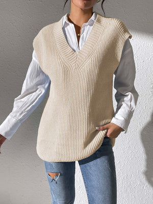 Beige textured knit V-neck sleeveless top over a white button-down shirt.