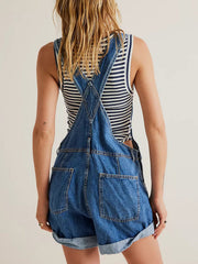 Medium wash denim overalls with cuffed shorts and a striped tank top.
