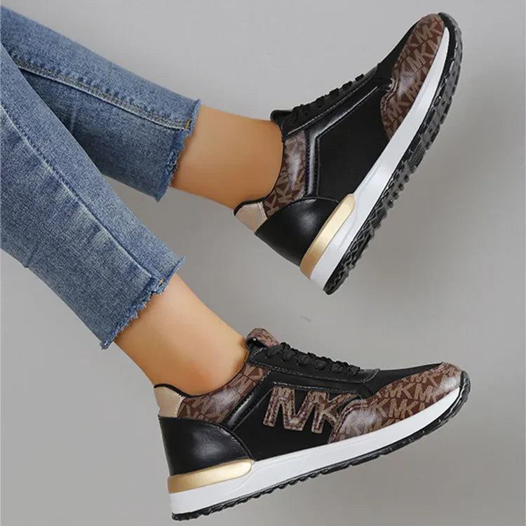 Black and caramel monogrammed runner sneakers with gold accents.