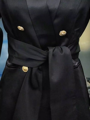 Black double-breasted blazer with gold buttons and a satin sash tie waist.