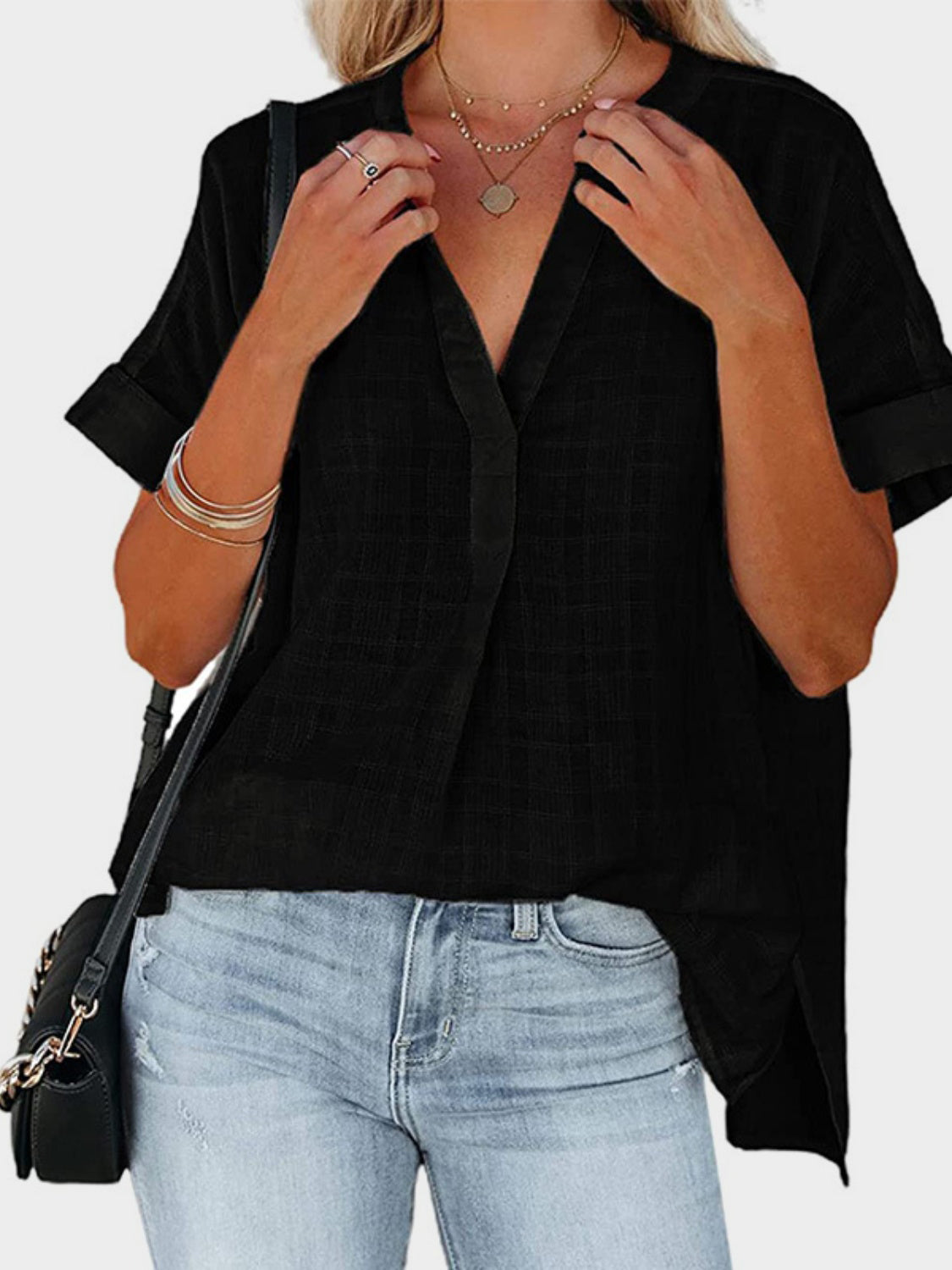 Black linen blend blouse with gathered yoke, V-neck, and cuffed short sleeves.