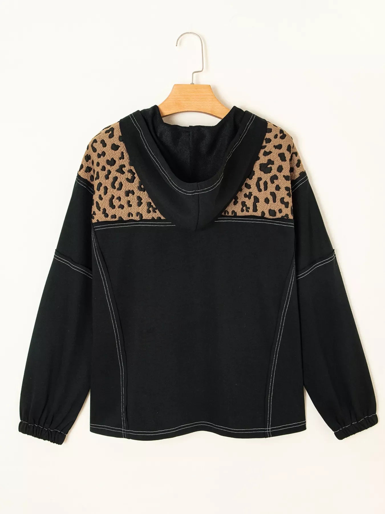 Black hoodie with leopard print shoulders and contrast stitching.