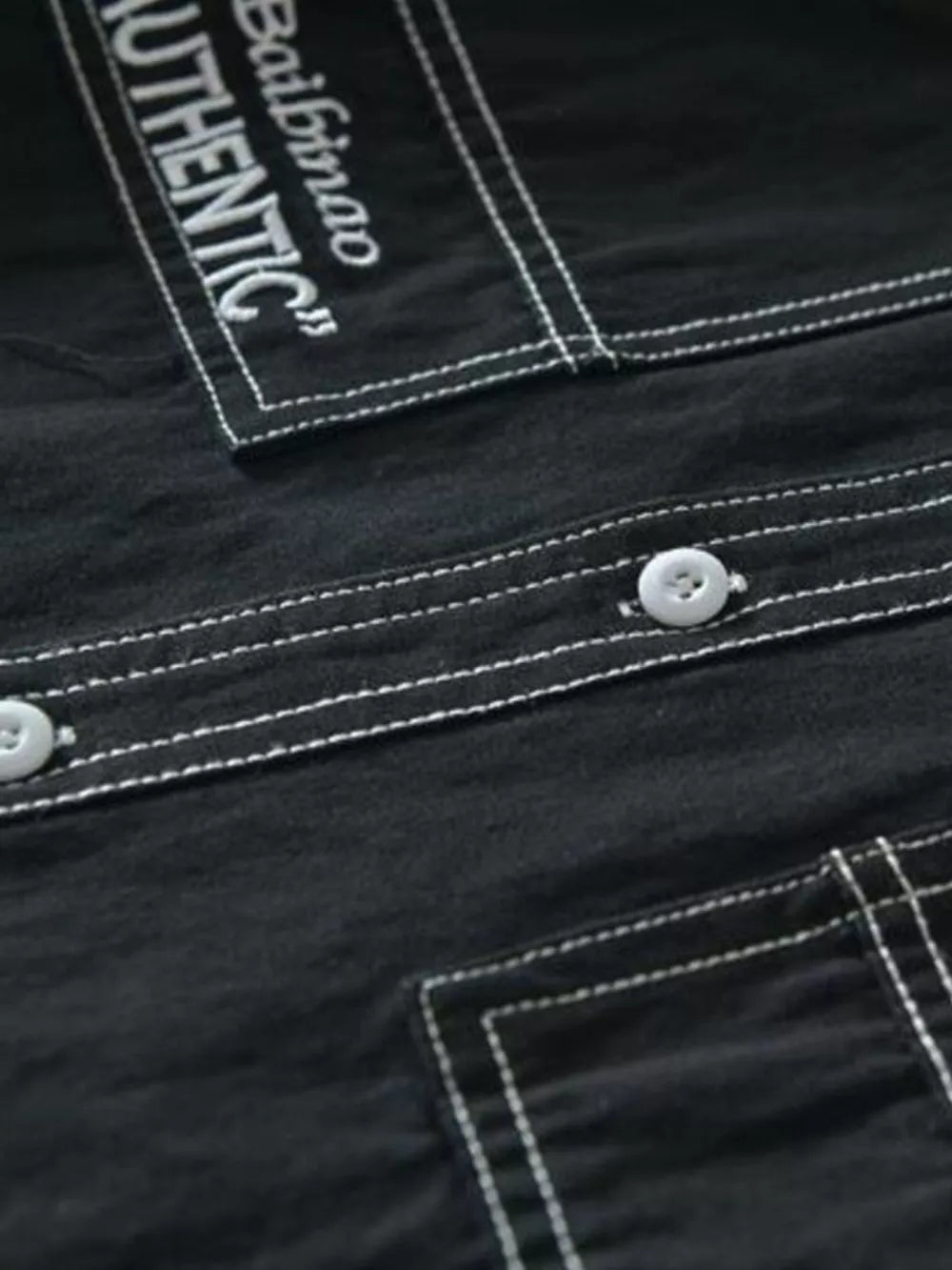 Black men's undershirt with contrast stitching and button-up detail.
