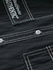Black men's undershirt with contrast stitching and button-up detail.