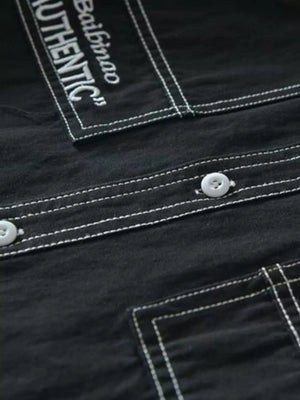 Black men's undershirt with contrast stitching and button-up detail.