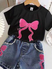 Black tee with pink bowknot graphic and pearl-trimmed denim shorts.
