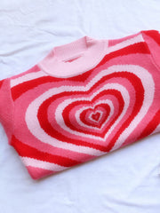 Pink knit sweater with mock neck and concentric heart stripe pattern in red and light pink.