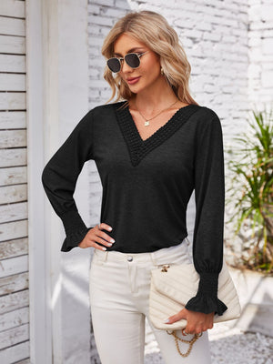 Black lace trim V-neck blouse with blouson sleeves and smocked cuffs.