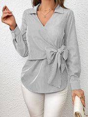 Striped wrap blouse with bow detail and V-neck.