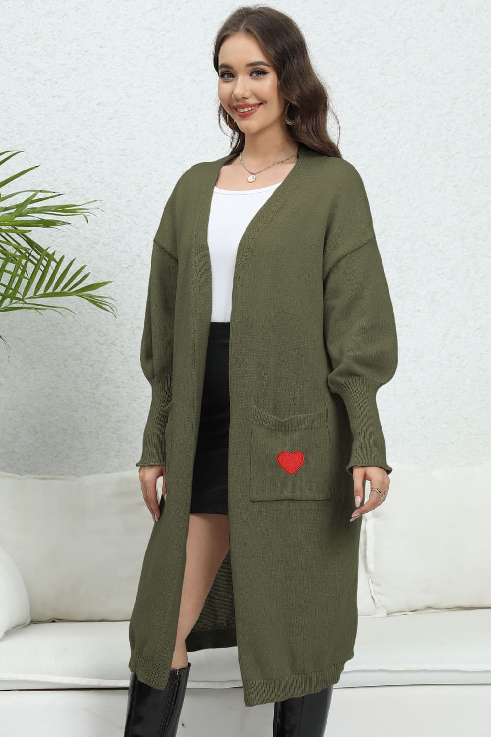 Army green long cardigan with balloon sleeves and a red heart embroidered on the pocket.
