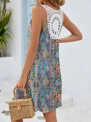 Botanical print mini dress with white crochet detail on back, sleeveless, A-line cut.