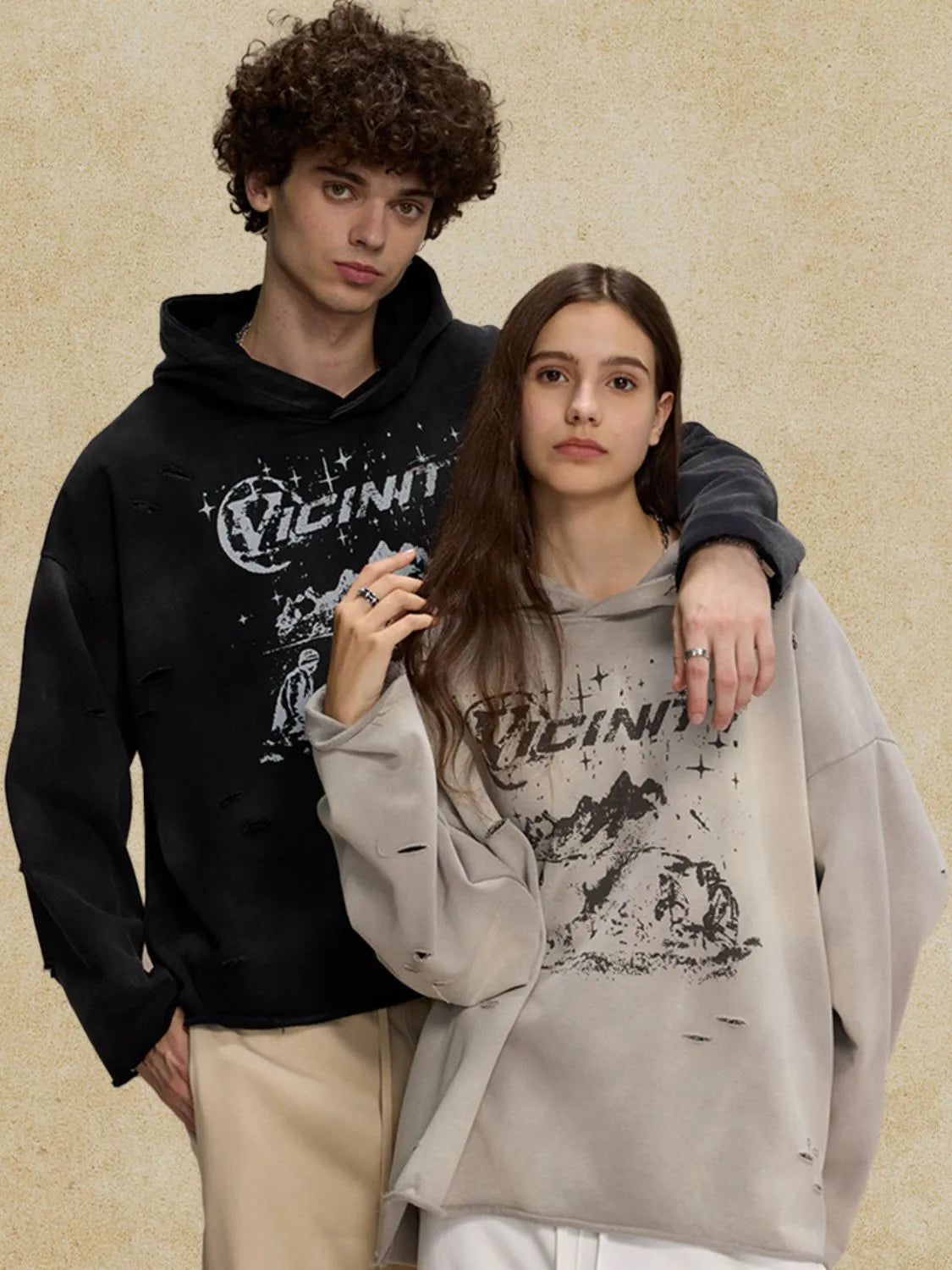 Black and gray distressed graphic oversized hoodies with distressed details and raw hems.