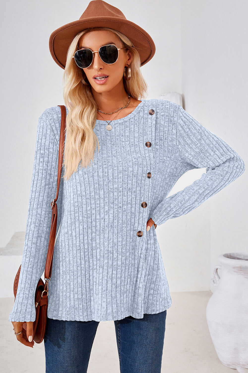 Light blue ribbed knit sweater with asymmetric button detail and crew neck.