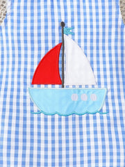 Blue gingham one-piece with sailboat appliqué and red sail.