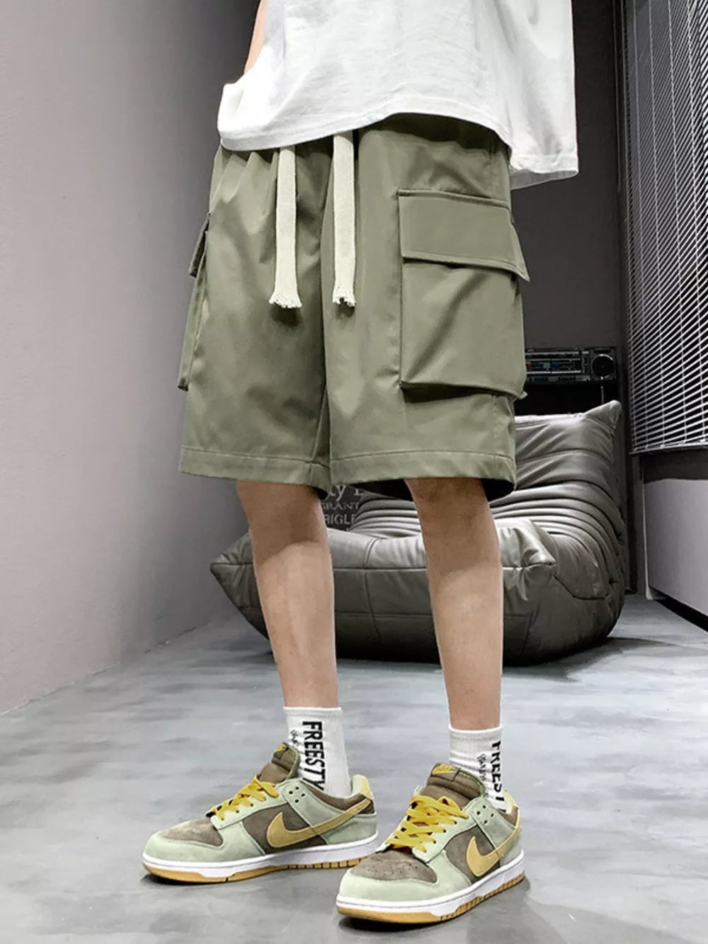 Relaxed fit army green cargo shorts with drawstring and multiple pockets.