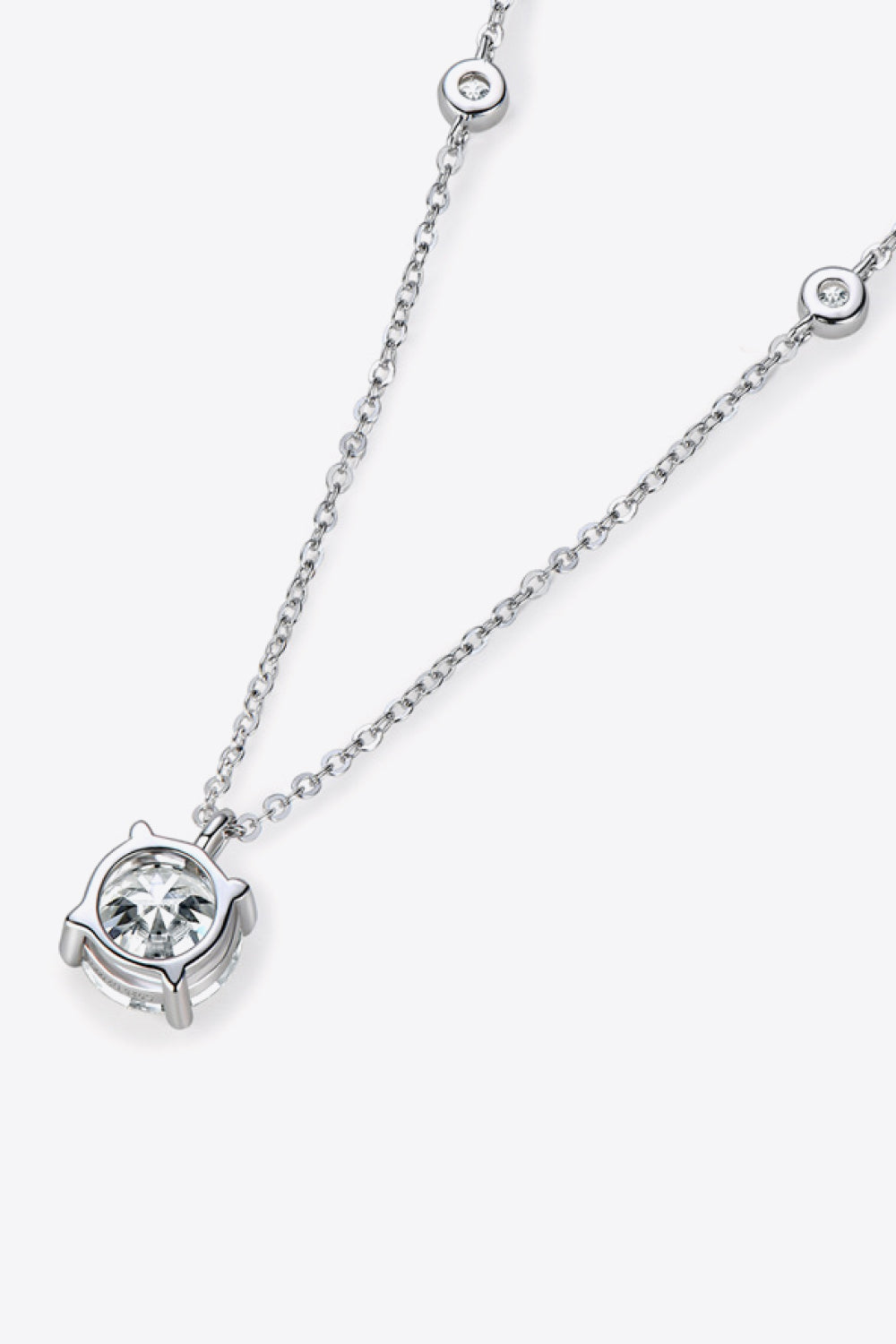 Silver moissanite solitaire necklace with a delicate chain and bezel-set stones.