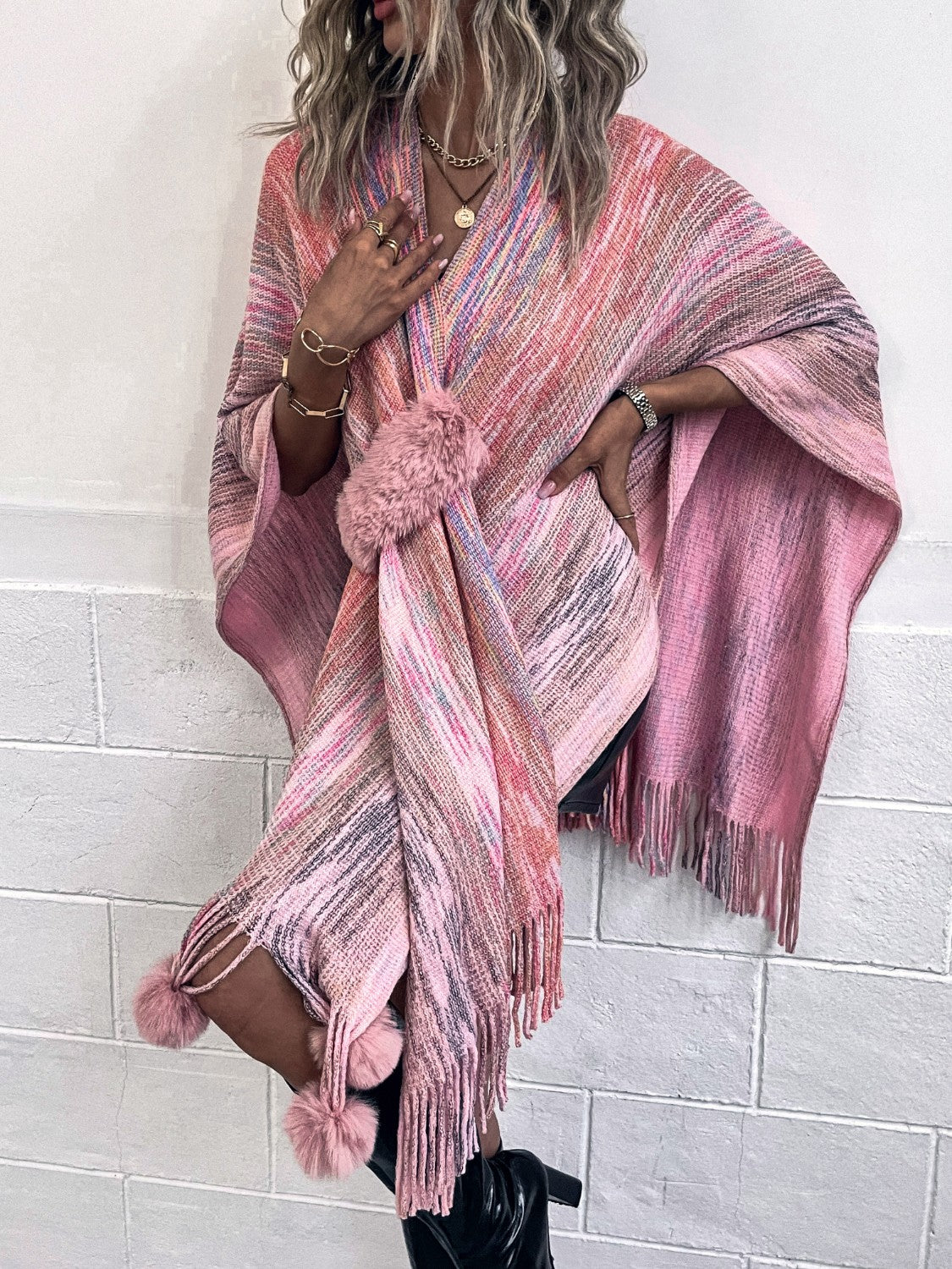 Pink multi-color knit wrap coat with fringe and pom-pom embellishments.