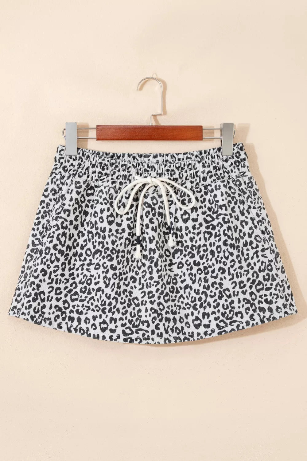 Leopard print denim skort in black and white with drawstring waist and pockets.