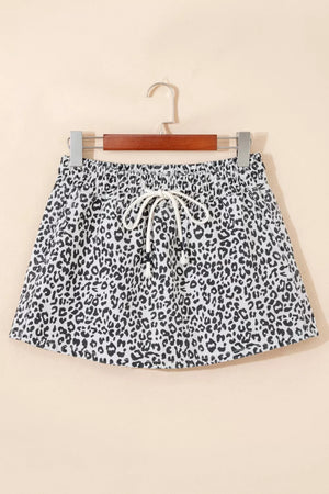 Leopard print denim skort in black and white with drawstring waist and pockets.