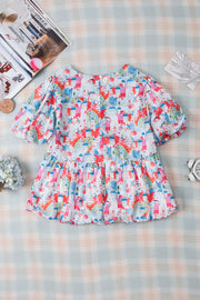Watercolor village print peplum blouse with short puff sleeves and tiered hem.