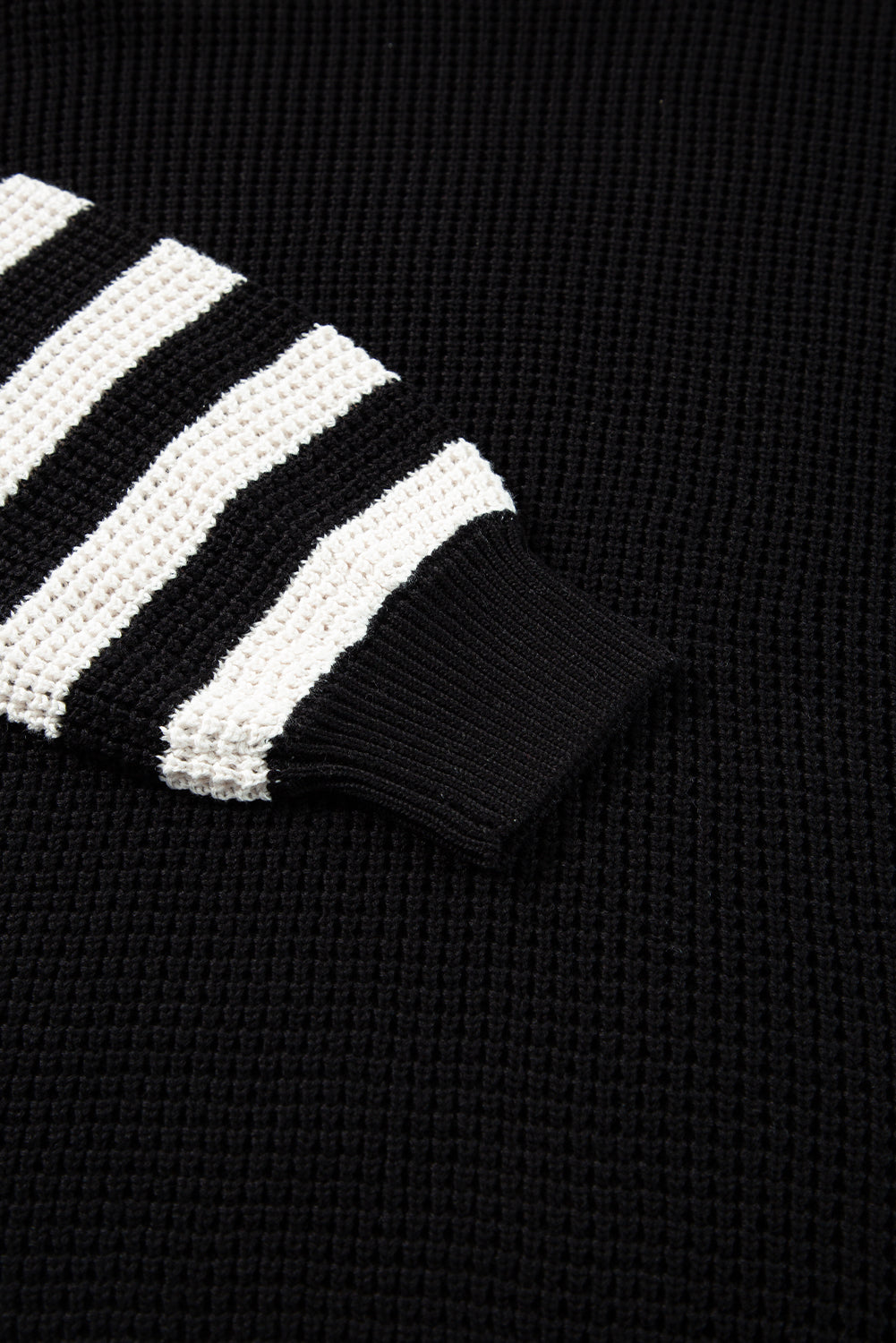 Black knit turtleneck sweater with white stripe sleeves