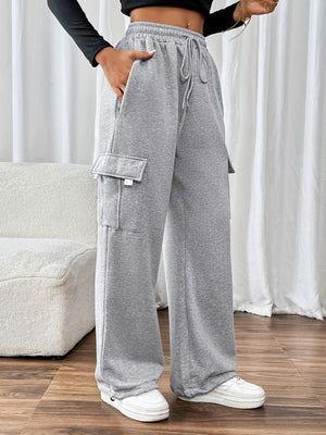 Light gray wide-leg cargo sweatpants with adjustable drawstring waist and side pockets.
