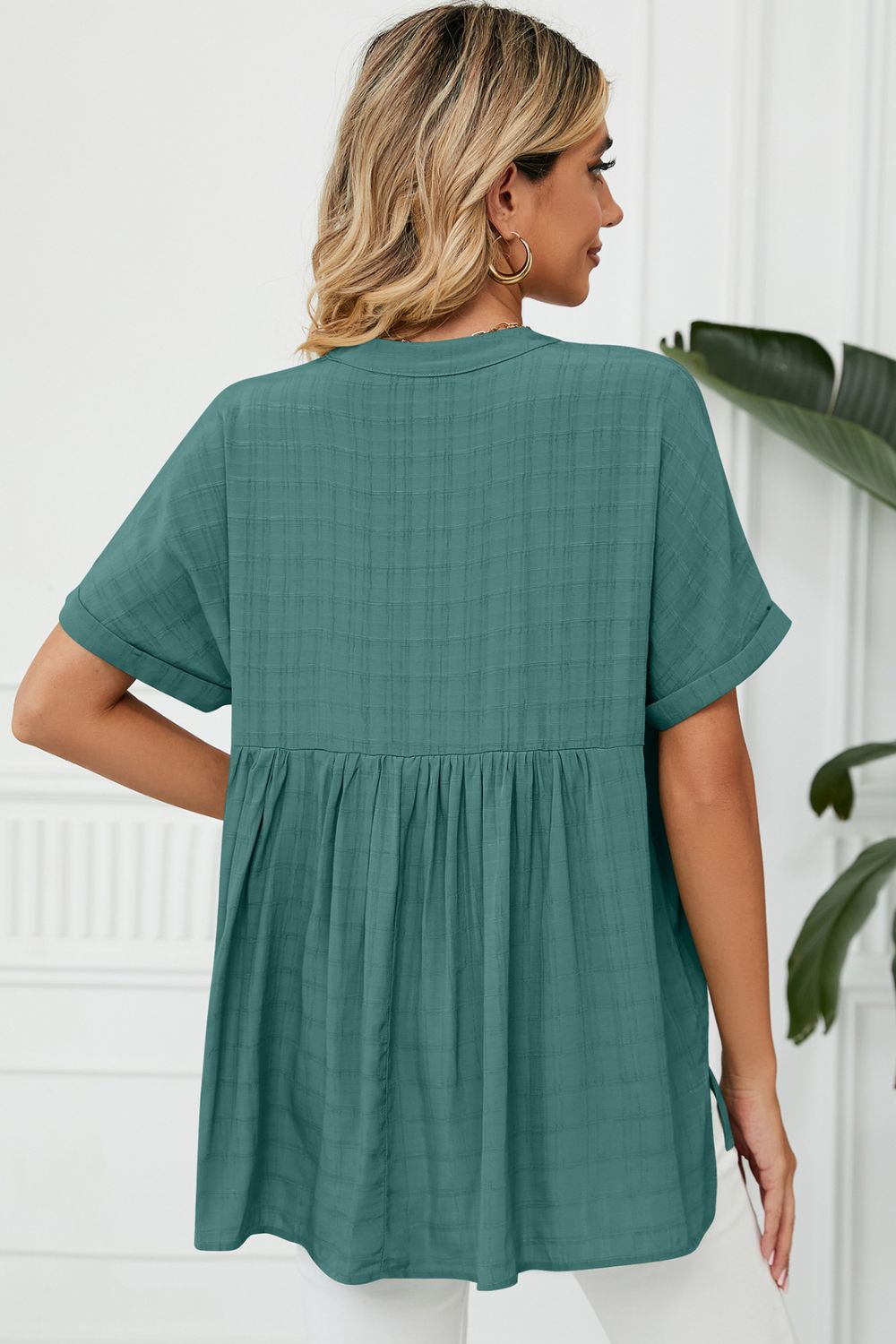 Turquoise linen blouse with gathered back detail and short sleeves.