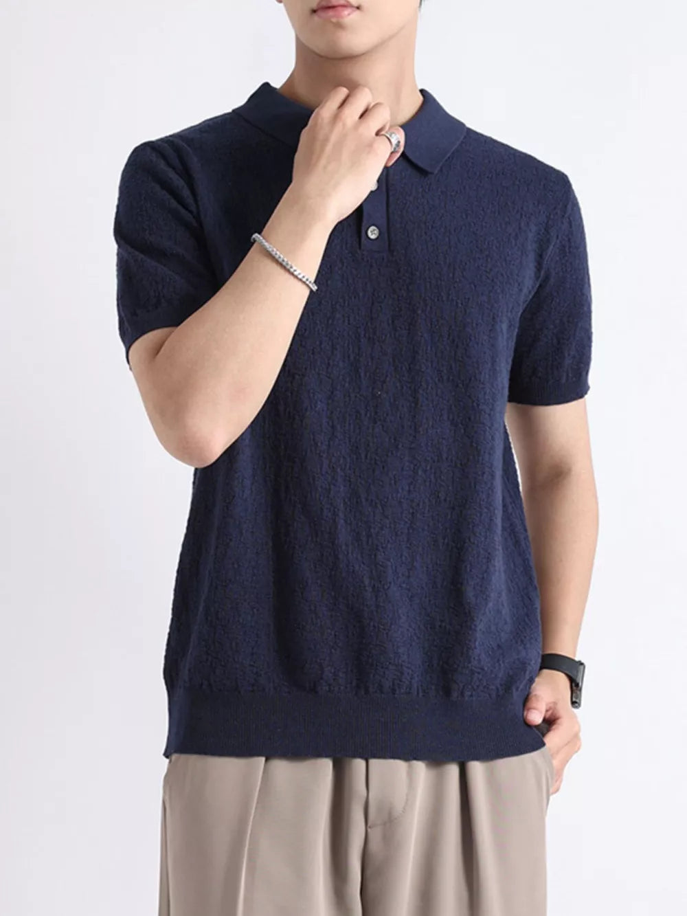 Navy short-sleeve knit polo shirt with button detail and classic collar.