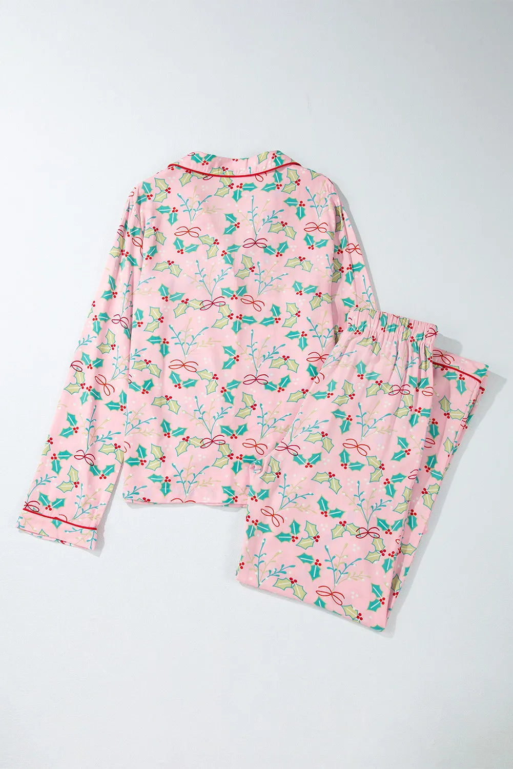 Blush pink pajama set with holly and bow print, long sleeves, and piped collar.