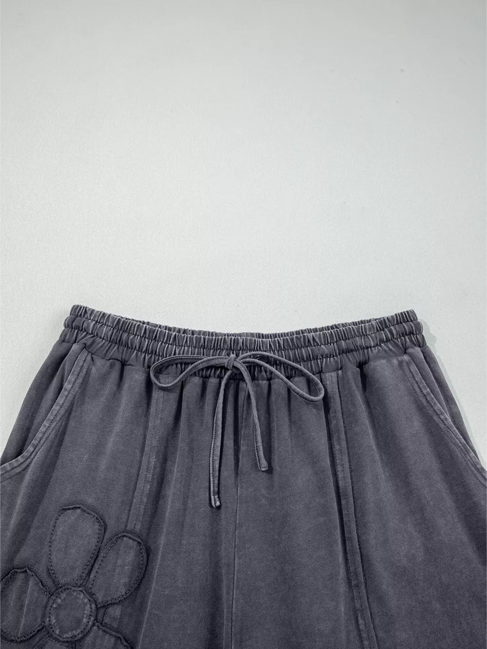 Maternity cropped wide-leg pants in charcoal cotton with floral applique and drawstring waist.
