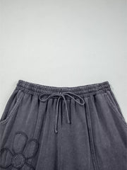 Maternity cropped wide-leg pants in charcoal cotton with floral applique and drawstring waist.
