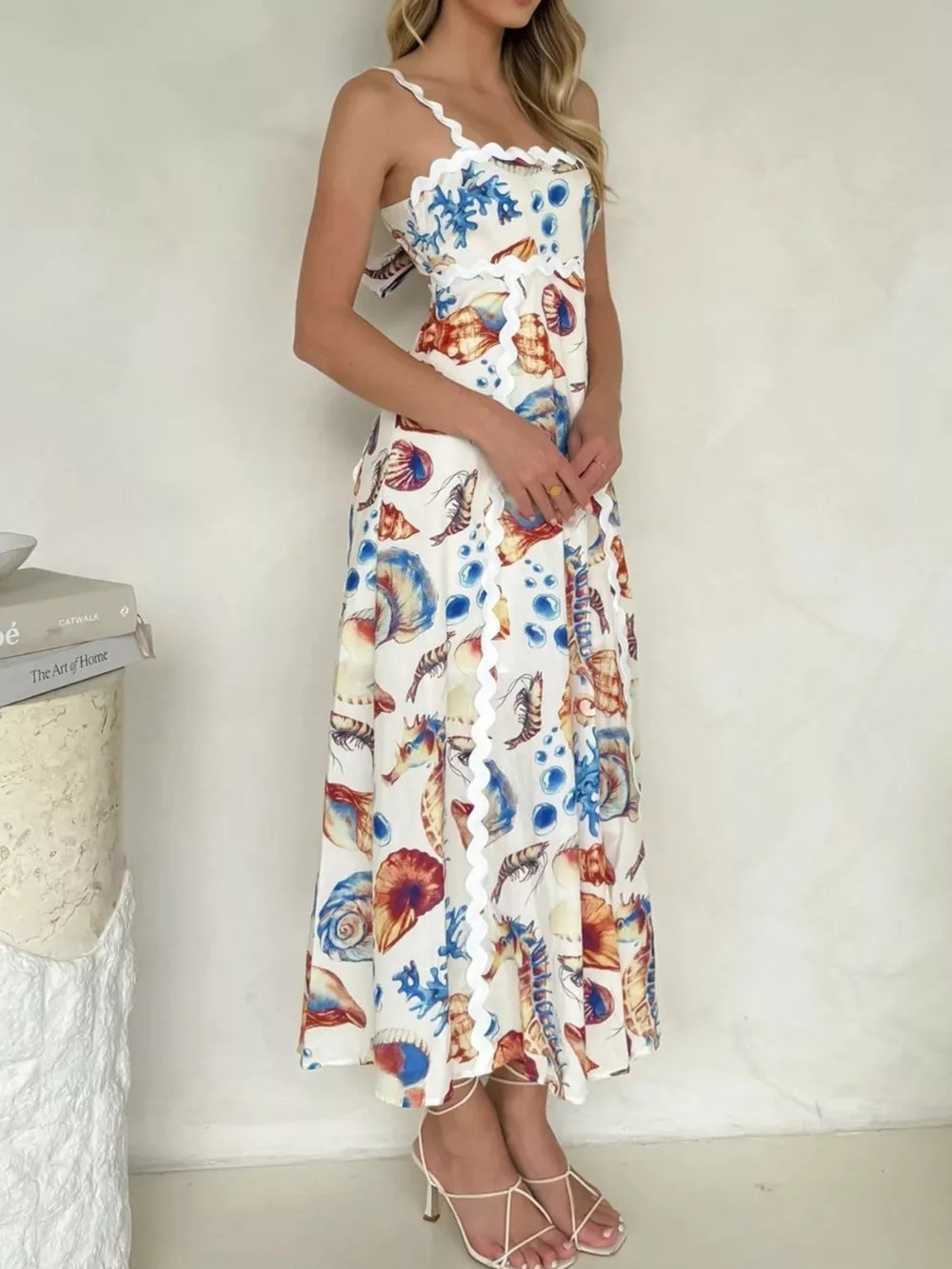 Midi dress with seashell print, scalloped trim, spaghetti straps, and tie back.