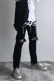 Black skinny fit jeans with distressed knees and frayed hem details.