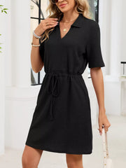 Black textured polo dress with drawstring waist and v-neckline.