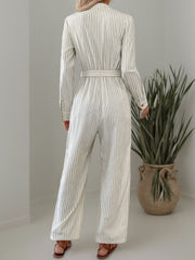 Beige vertical stripe button-down jumpsuit with belted waist and wide legs.